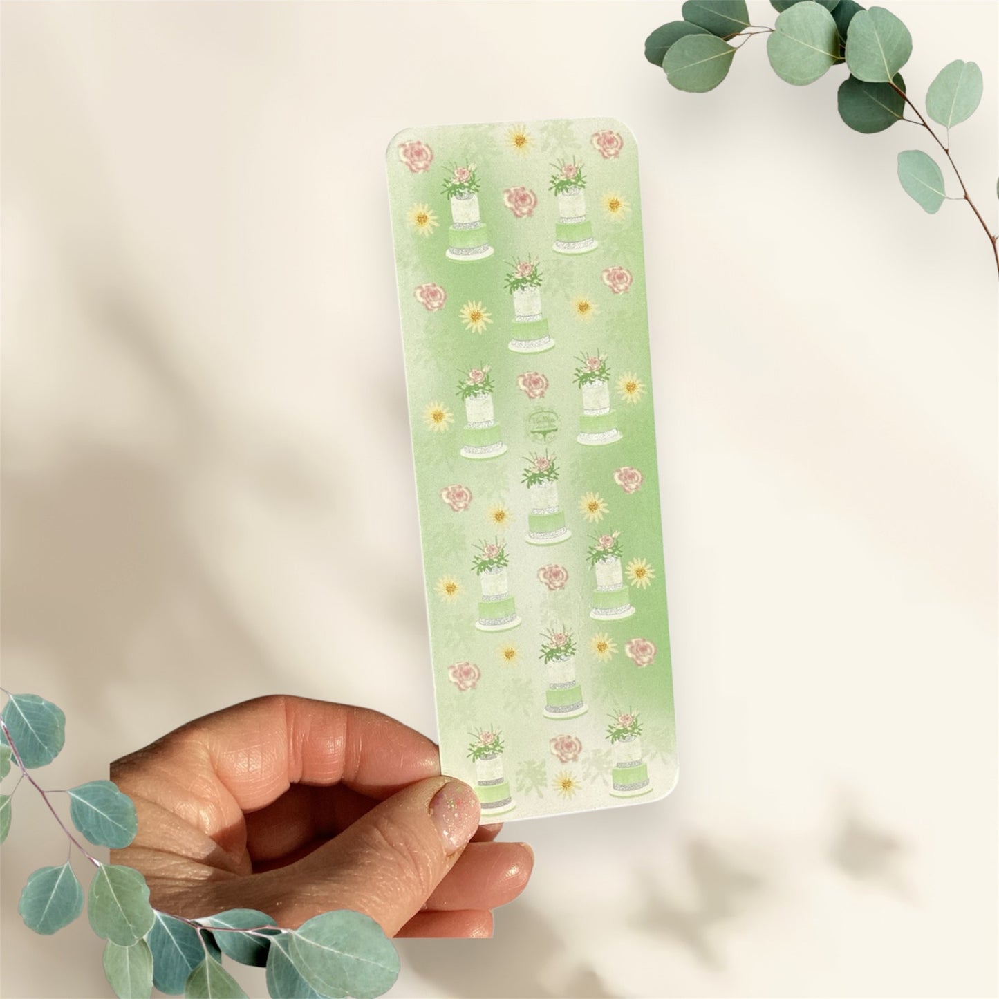 Close-up of green floral bookmark showing detailed cake tier design and premium finish"