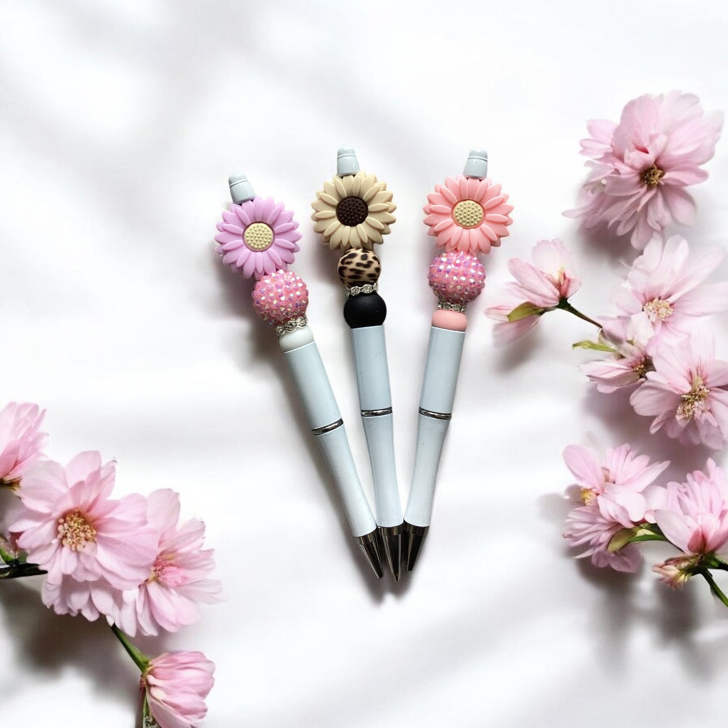 "Close-up view of pink daisy acrylic beads on decorative pen"